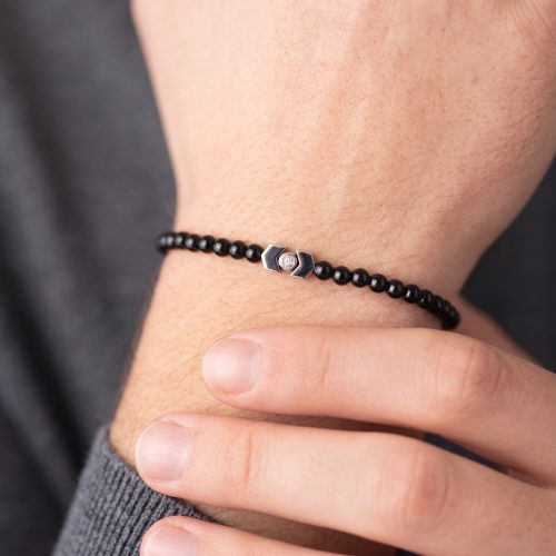 Zwarte natuurstenen herenarmband gedragen om een mannenpols