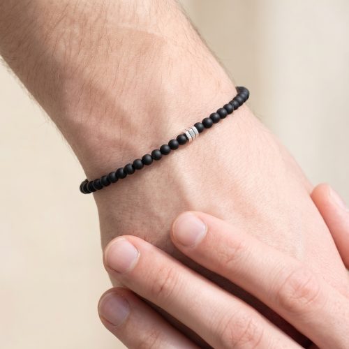 Mat zwarte natuurstenen herenarmband gedragen om een mannenpols
