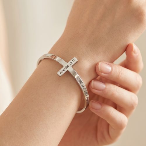 Zilveren kruisarmband met bijbeltekst Jeremiah 29:11 gedragen om de pols