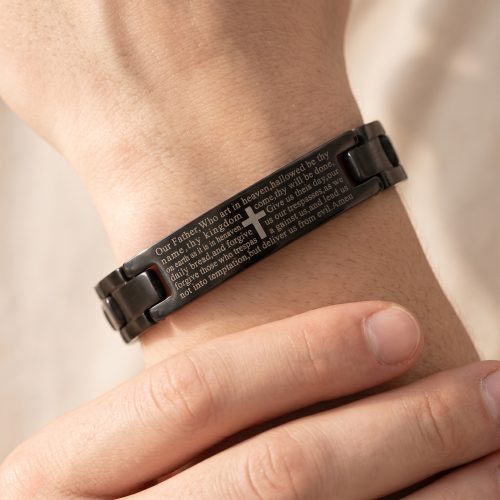 Zwarte herenarmband met Onze Vader-gebed gedragen om een mannenpols
