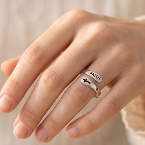 Verstelbare zilveren ring met kruisje en Faith gedragen aan de vinger