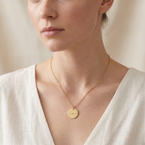 Gouden ketting met be still hanger gedragen om de hals