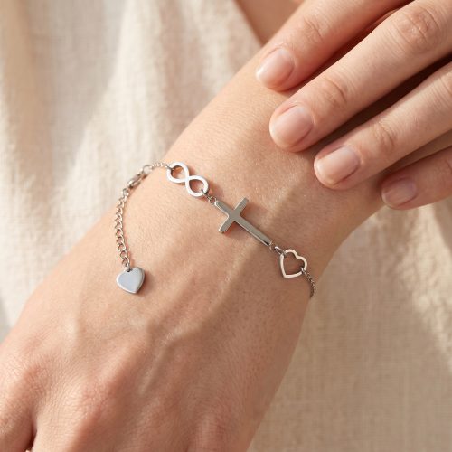 Zilveren armband met kruisje, infinity en hartje gedragen om de pols