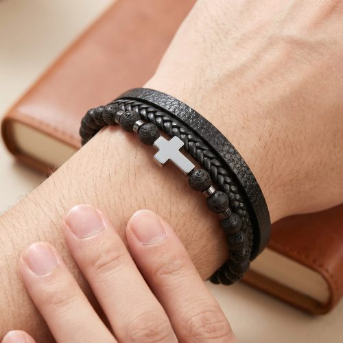 Zwarte leren wikkelarmband met kruis gedragen om een mannenpols